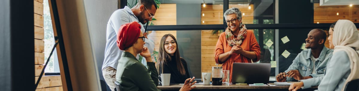 A group of diverse business people having a meeting and smiling round a table